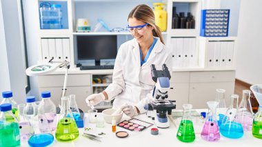 Laboratuvarda makyaj yapan genç İspanyol bilim kadını.