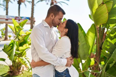 Man and woman couple kissing and hugging each other standing at street