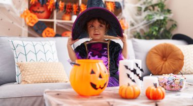 Adorable hispanic girl smiling confident wearing halloween costume at home