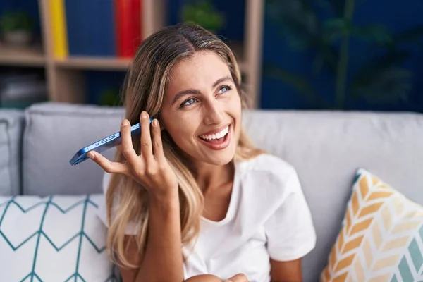 Young Blonde Woman Listening Voice Message Smartphone Sitting Sofa Home — Stockfoto