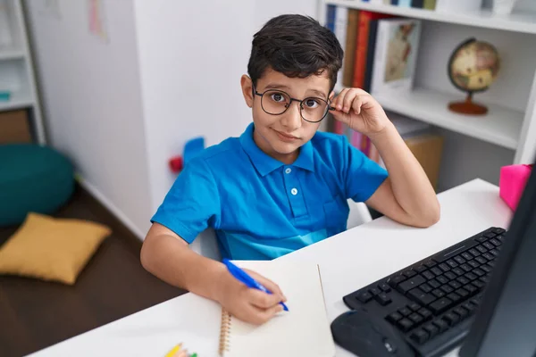 Adorable Hispanic Boy Student Using Computer Writing Notebook Classroom — 图库照片