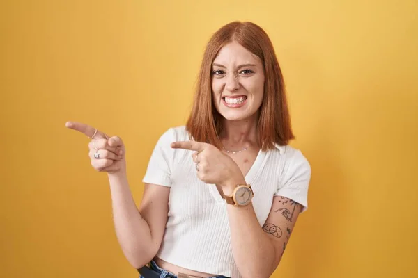 Young Redhead Woman Standing Yellow Background Pointing Aside Worried Nervous —  Fotos de Stock