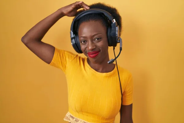 African Woman Curly Hair Standing Yellow Background Wearing Headphones Confuse — Stock Photo, Image