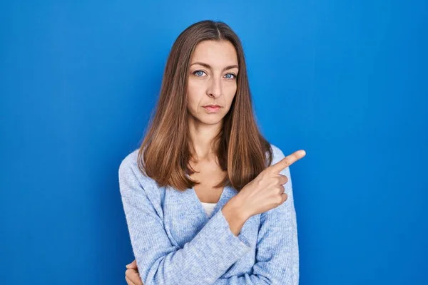 Young Woman Standing Blue Background Pointing Hand Finger Side Showing — Stock Photo, Image