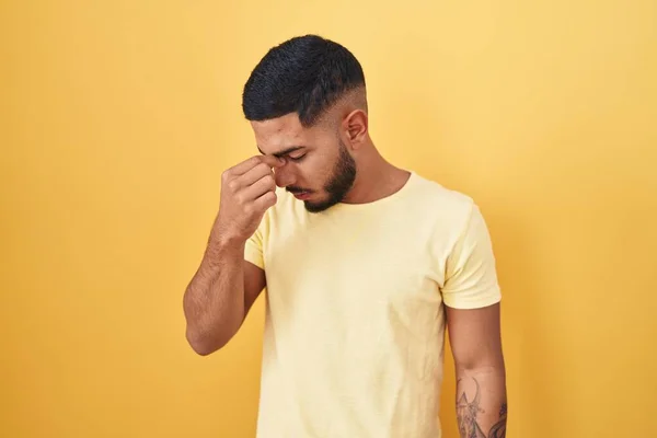 Young Hispanic Man Standing Yellow Background Tired Rubbing Nose Eyes — Stock Photo, Image