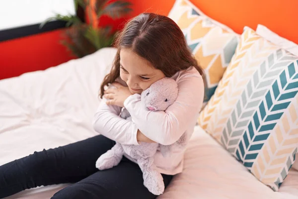 Adorable Hispanic Girl Hugging Rabbit Doll Sitting Bed Bedroom — Stok fotoğraf