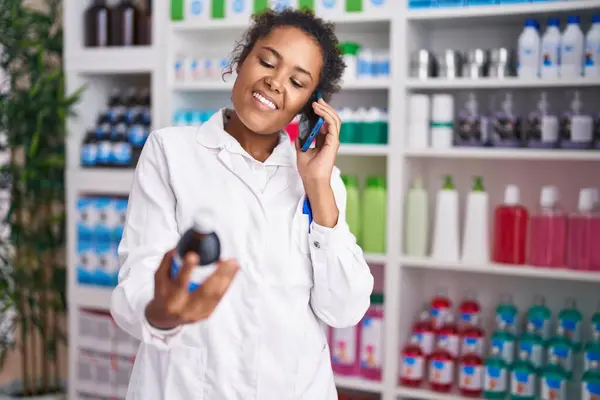 Afroamerikansk Kvinna Farmaceut Håller Medicinflaska Talar Smartphone Apotek — Stockfoto