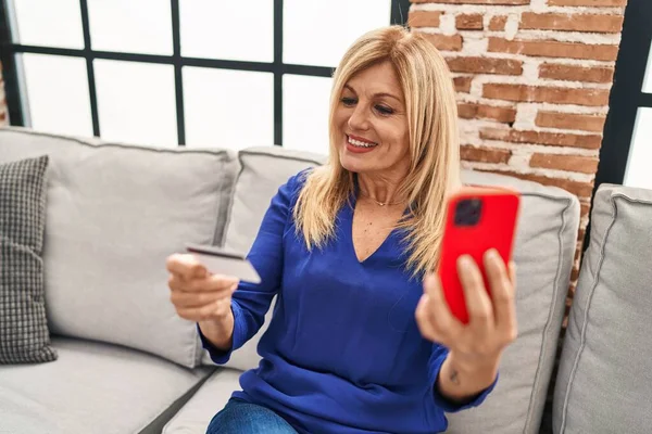 Blonde Frau Mittleren Alters Benutzt Smartphone Und Kreditkarte Hause — Stockfoto