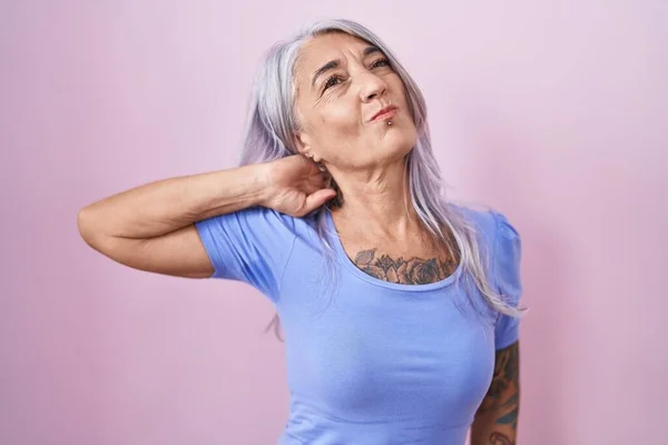 Mujer Mediana Edad Con Tatuajes Pie Sobre Fondo Rosa Sufriendo — Foto de Stock