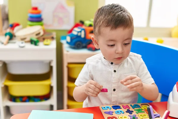 Adorable Hispanic Toddler Playing Maths Puzzle Game Sitting Table Kindergarten — Fotografia de Stock