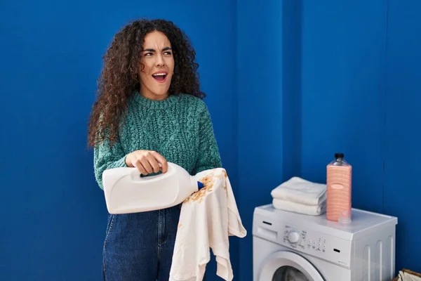 Ung Latinamerikansk Kvinna Som Håller Smutstvätt Och Tvättmedel Flaska Arg — Stockfoto