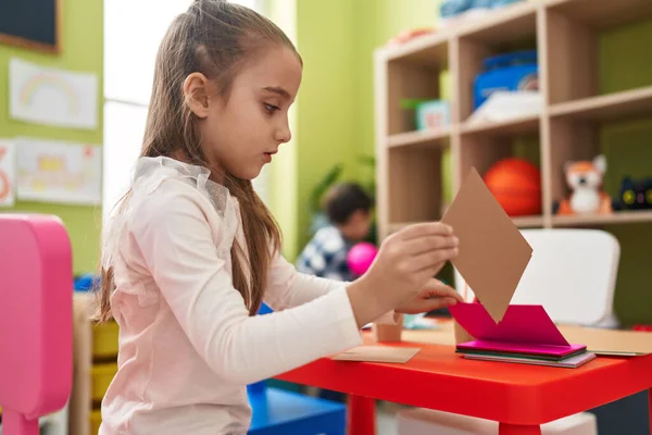 Adorable Hispanic Girl Sitting Table Holding Paper Kindergarten — Foto Stock