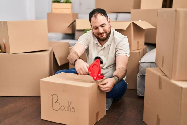 Young Hispanic Man Smiling Confident Packing Cardboard Box New Home — Stock fotografie