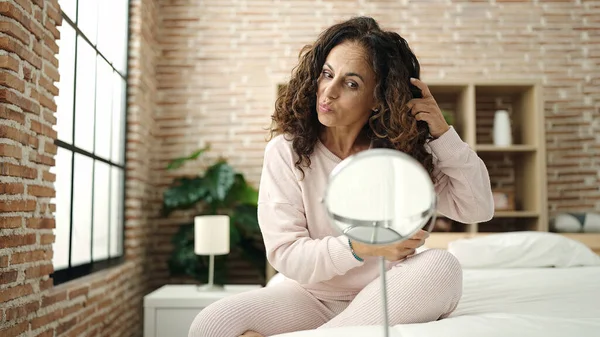 Middle Age Hispanic Woman Combing Hair Hand Sitting Bed Bedroom — Fotografia de Stock