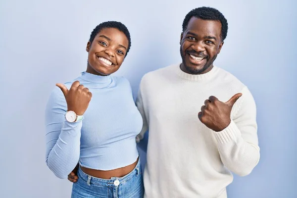 Молодая Африканская Американская Пара Стоящая Синем Фоне Указывая Спину Поднятой — стоковое фото