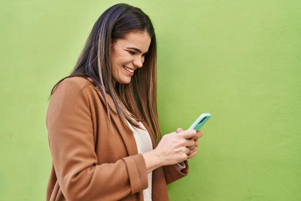Young Beautiful Hispanic Woman Smiling Confident Using Smartphone Isolated Green — ストック写真