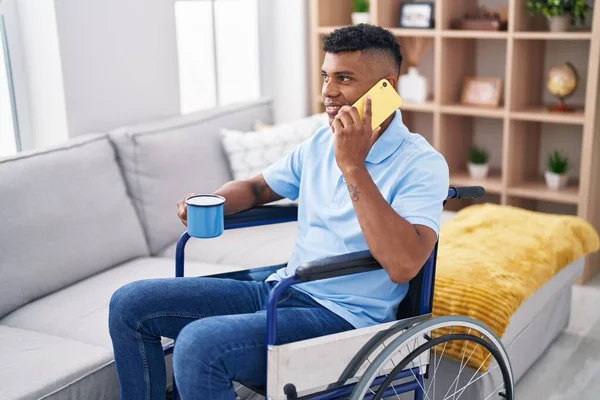 Young Latin Man Talking Smartphone Drinking Coffee Sitting Wheelchair Home — Stok fotoğraf