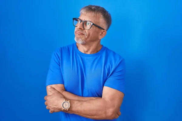 Hispanic Man Grey Hair Standing Blue Background Looking Side Arms — Stockfoto