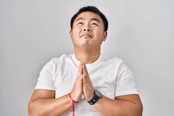 Young Chinese Man Standing White Background Begging Praying Hands Together — Stock Photo, Image