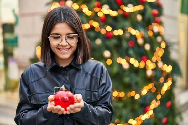 Νεαρή Όμορφη Ισπανόφωνη Γυναίκα Χαμογελά Αυτοπεποίθηση Κρατώντας Μπάλα Χριστουγεννιάτικη Διακόσμηση — Φωτογραφία Αρχείου
