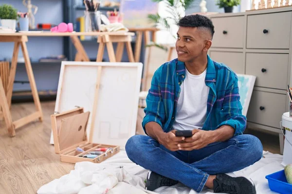 Young Latin Man Artist Using Smartphone Sitting Floor Art Studio — Stock Photo, Image