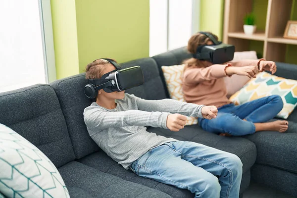 Two kids playing video game using virtual reality glasses at home