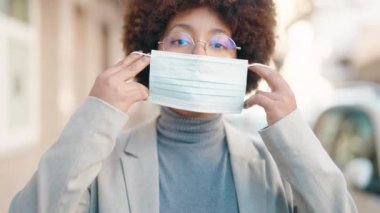 African american woman smiling confident wearing medical mask at street