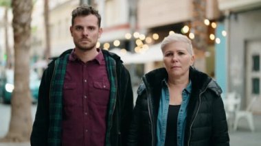 Mother and son smiling confident standing with arms crossed gesture at street