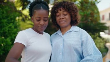 African american women mother and daughter doing heart gesture with hands at park