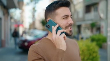 Sokakta akıllı telefon kullanan, kendine güvenen genç bir İspanyol.