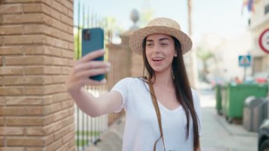 Young hispanic woman tourist smiling confident having video call at street