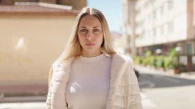 Sokakta kendine güvenen genç sarışın kadın gülümsüyor