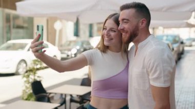 Man and woman couple smiling confident having video call at street