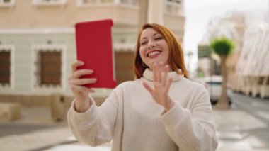 Genç kızıl saçlı kadın gülümsüyor.