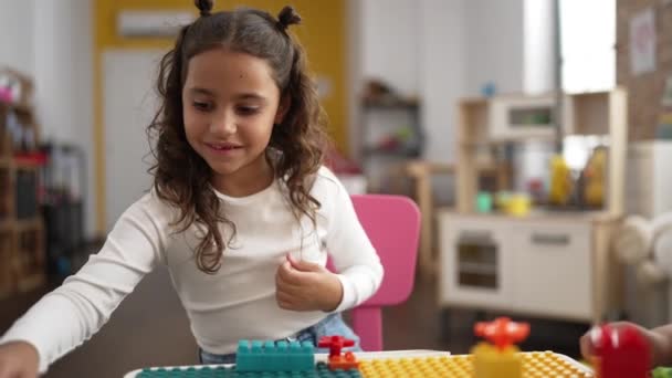 Adorable Hispanic Girl Playing Construction Blocks Sitting Table Classroom — Wideo stockowe