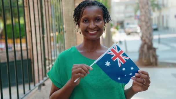 中年非洲裔美国妇女微笑着 自信地在街上举着澳大利亚国旗 — 图库视频影像