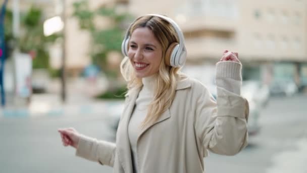 Młoda Blondynka Uśmiecha Się Pewnie Słuchając Muzyki Ulicy — Wideo stockowe