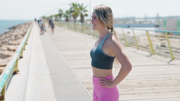 Νεαρή Ξανθιά Γυναίκα Που Φοράει Αθλητικά Και Αναπνέει Στην Παραλία — Αρχείο Βίντεο