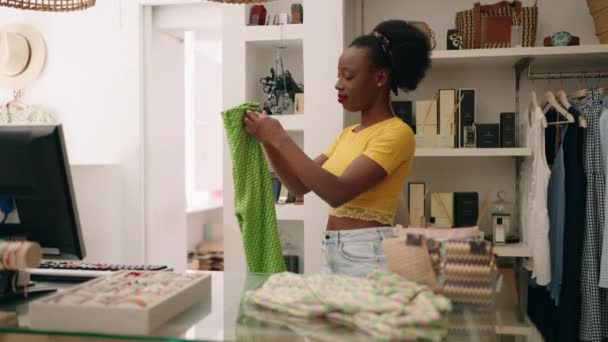 Afroamerikanische Verkäuferin Faltet Kleidung Bekleidungsgeschäft — Stockvideo