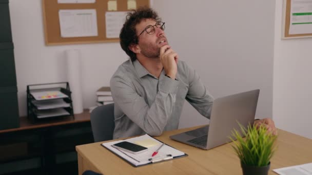 Молодой Латиноамериканец Бизнесмен Использует Ноутбук Сомнительным Выражением Офисе — стоковое видео