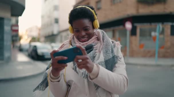 Junge Afroamerikanerin Spielt Videospiel Mit Smartphone Und Kopfhörer Auf Der — Stockvideo