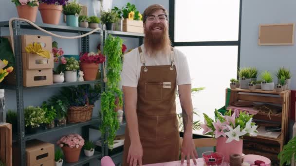 红头发的年轻花匠自信地站在花店旁微笑 — 图库视频影像