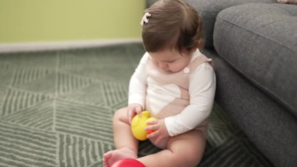 愛らしい幼児遊びますとともにアヒルおもちゃ座っています床にホーム — ストック動画