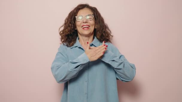Kobieta Średnim Wieku Uśmiechnięta Rękami Sercu Różowym Tle — Wideo stockowe