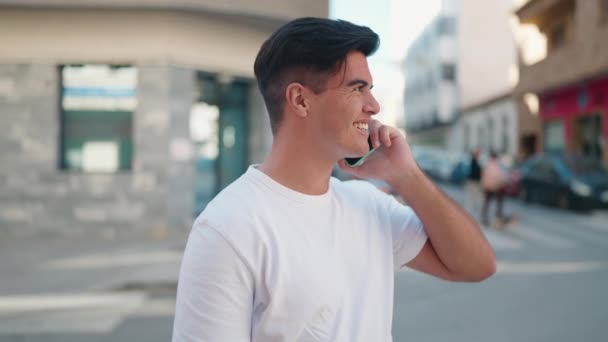 年轻的惊慌失措的男人在街上用智能手机自信地微笑着 — 图库视频影像
