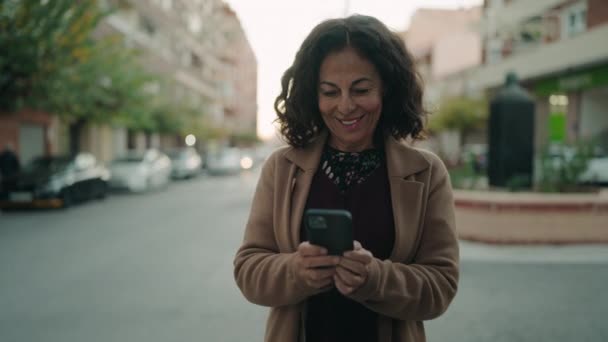 Μέση Ηλικία Ισπανόφωνη Γυναίκα Χαμογελά Αυτοπεποίθηση Χρησιμοποιώντας Smartphone Στο Δρόμο — Αρχείο Βίντεο