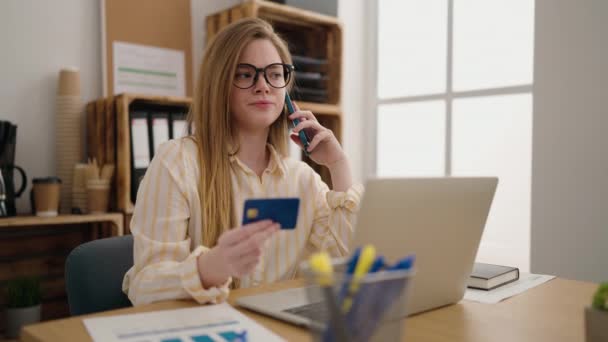 Genç Sarışın Kadını Ofiste Elinde Kredi Kartıyla Akıllı Telefondan Konuşuyor — Stok video