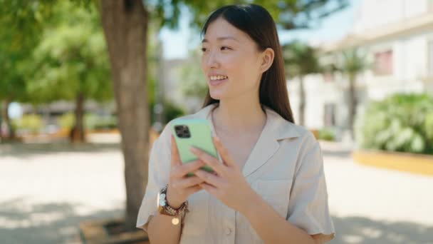 Kínai Mosolygós Magabiztos Segítségével Smartphone Parkban — Stock videók