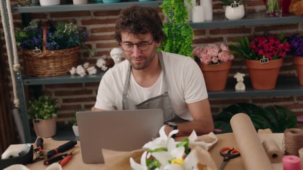 Young Hispanic Man Florist Using Laptop Flower Shop — Stockvideo