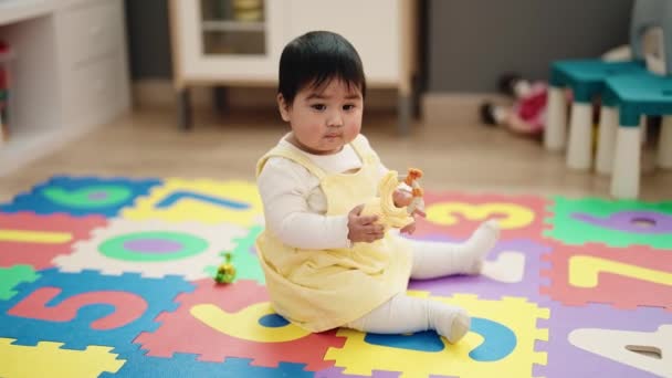 Adorable Hispanic Baby Holing Toy Sitting Floor Kindergarten — Wideo stockowe